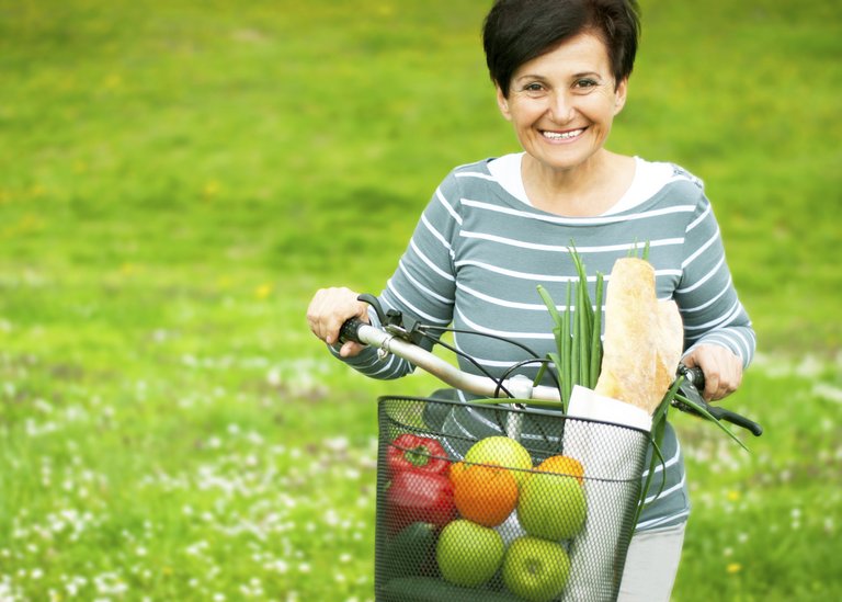 [Translate to Russia - Russian:] Woman on a bike with healthy food in the basket